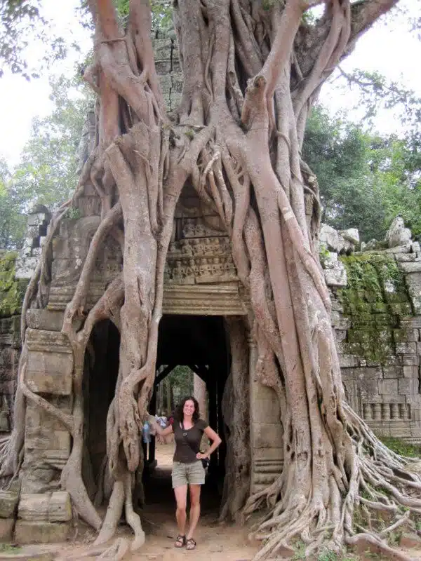 Me by a tree that's taken over an Angkor Wat temple.