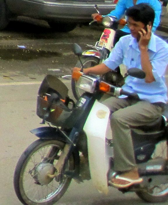 Talking on the phone while riding a moto.