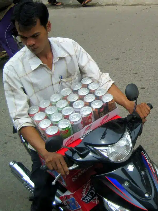 Carrying many cans of soda on a motorbike!