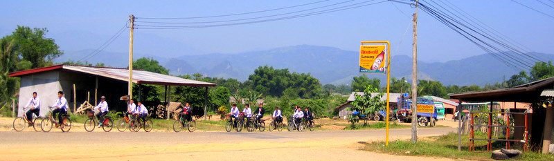 Schoolkids on bikes in Laos.