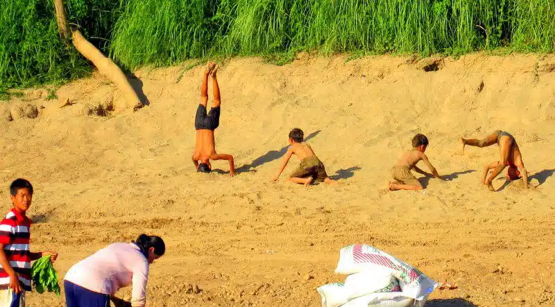 Boys playing on an island on the Mekong River.