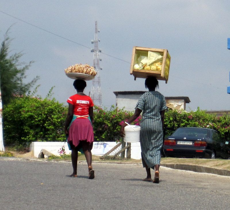 Vendors balancing food containers on their heads.