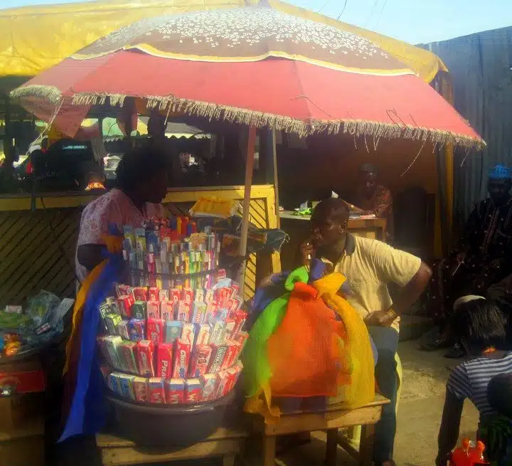 An Accra vendor under a sun shade.