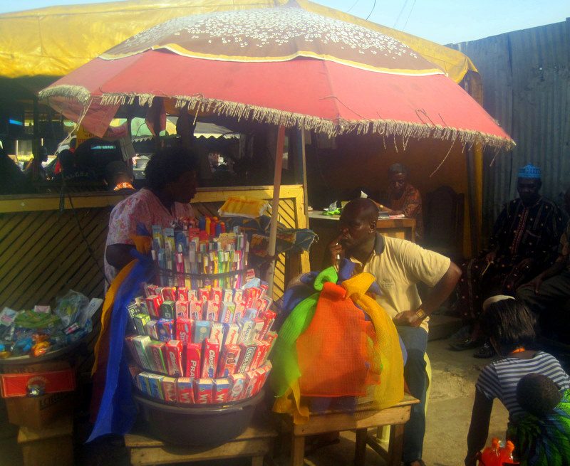 An Accra vendor under a sun shade.