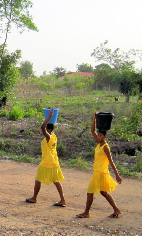 Girls carrying water on their head in Ghana.