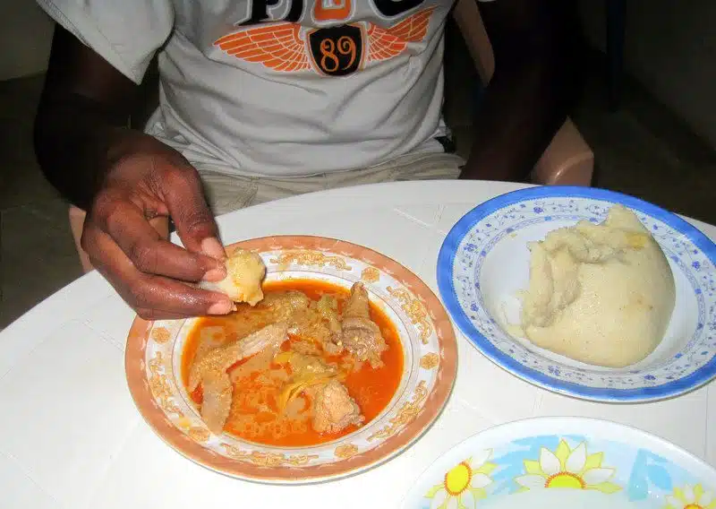 Eating banku with hands.