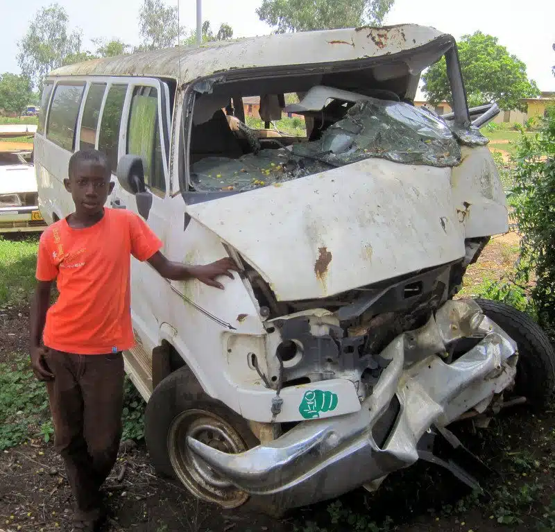 Elikem with a wrecked tro tro.
