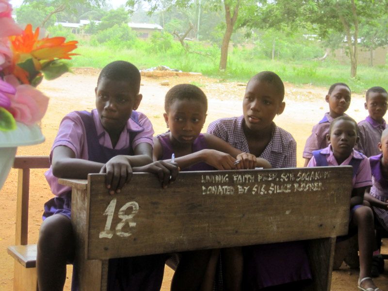Children sharing a desk in Ghana.