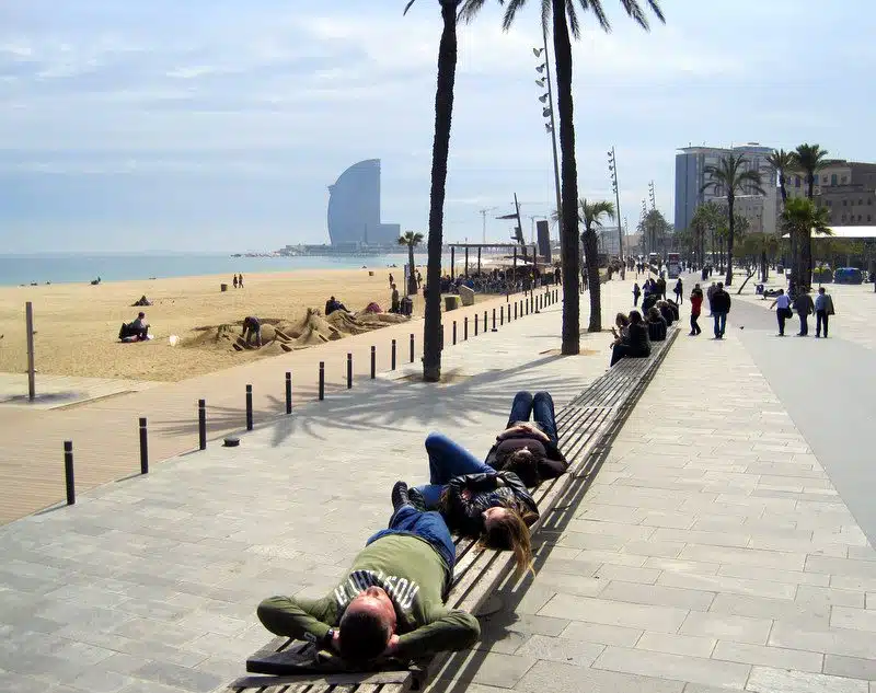 Laying on benches on the beach in Barcelona.
