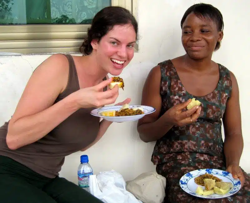 Scarfing delicious food in Ghana as Millicent chuckles.