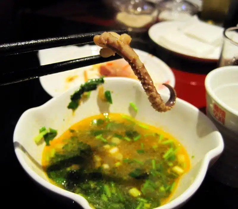 Dipping squid in oil during Hot Pot.