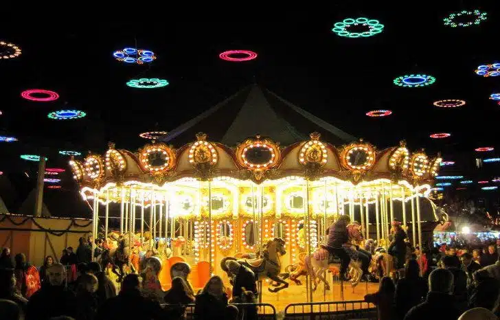 The carousel in Madrid's Plaza Mayor spins gold under rainbow circle lights for the holidays!