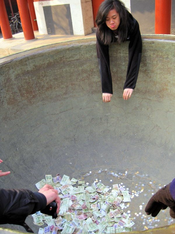 Aww, poor thing can't reach the money pot at Lama Temple!