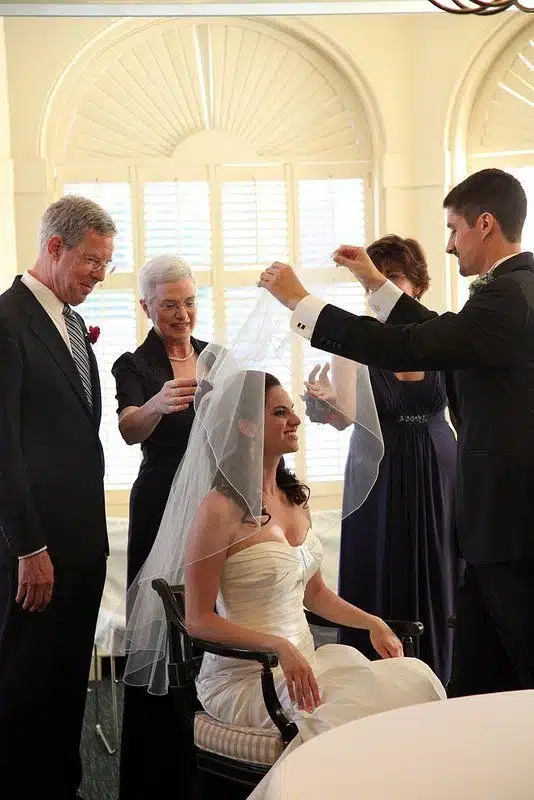 In the Bedekken ceremony, the groom puts the veil over his bride.