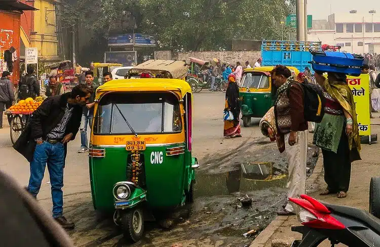 A couple carries their suitcases on their head as they hail an auto rickshaw by the Railway Station.