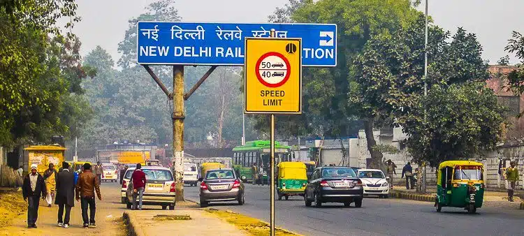 Cars, auto rickshaws, and pedestrians meet in New Delhi.