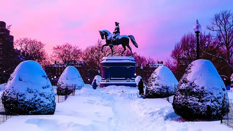 Boston Public Garden under two feet of snow with a sunset in back.