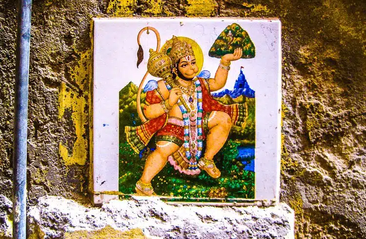 Why is it brilliant to hang this and other religious figures on an alley wall in India? 