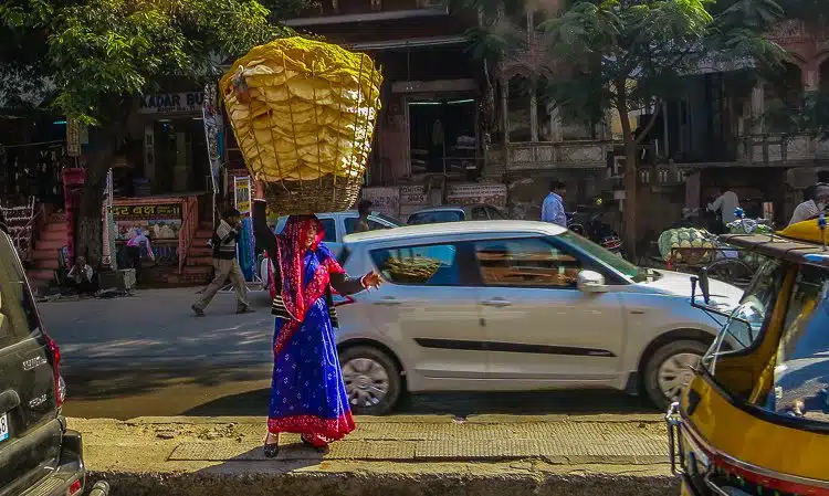 Selling a giant head-basket of bread by the roadside in a dreamy sari. 