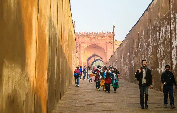 A pack of colorfully-dressed Indian students strides into Agra Fort.