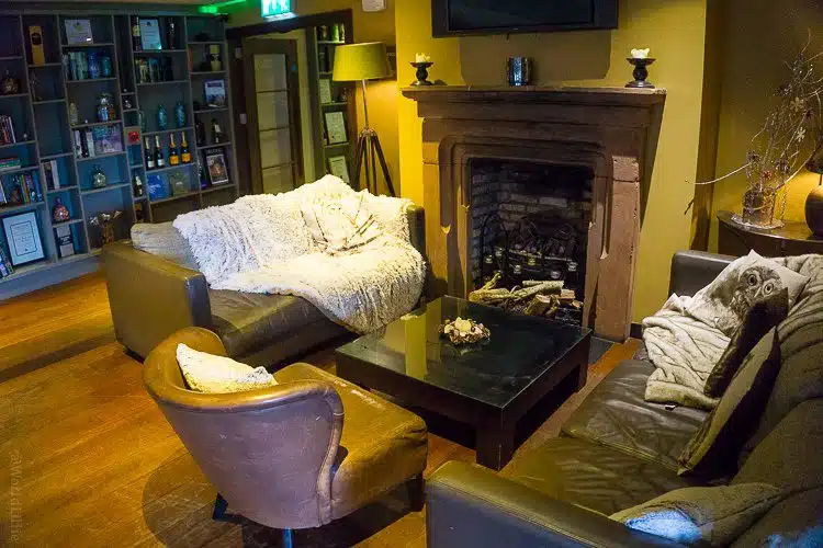 The fireplace and blanketed sofa you see walking into The Pins Gastropub.