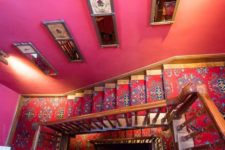 Bold red walls and ornate carpeting in the stairways.
