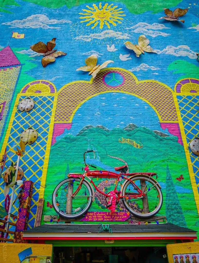 Bike on a wall? Why not? Randyland is the best free place to visit in Pittsburgh, PA for colorful photos, fun, & creative humor! See psychedelic rainbow photos from a visiting teacher. #Pittsburgh #Randyland #Travel #Color #Design #Creativity
