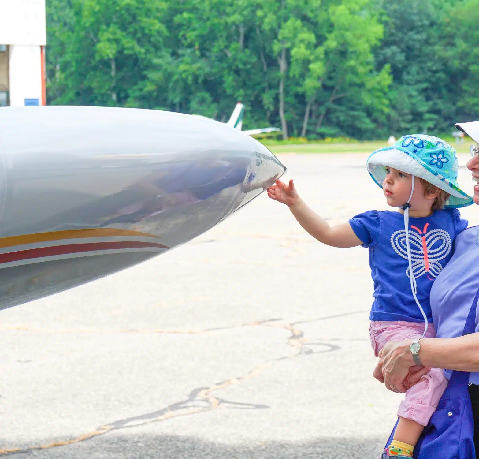Child touching airplane nose