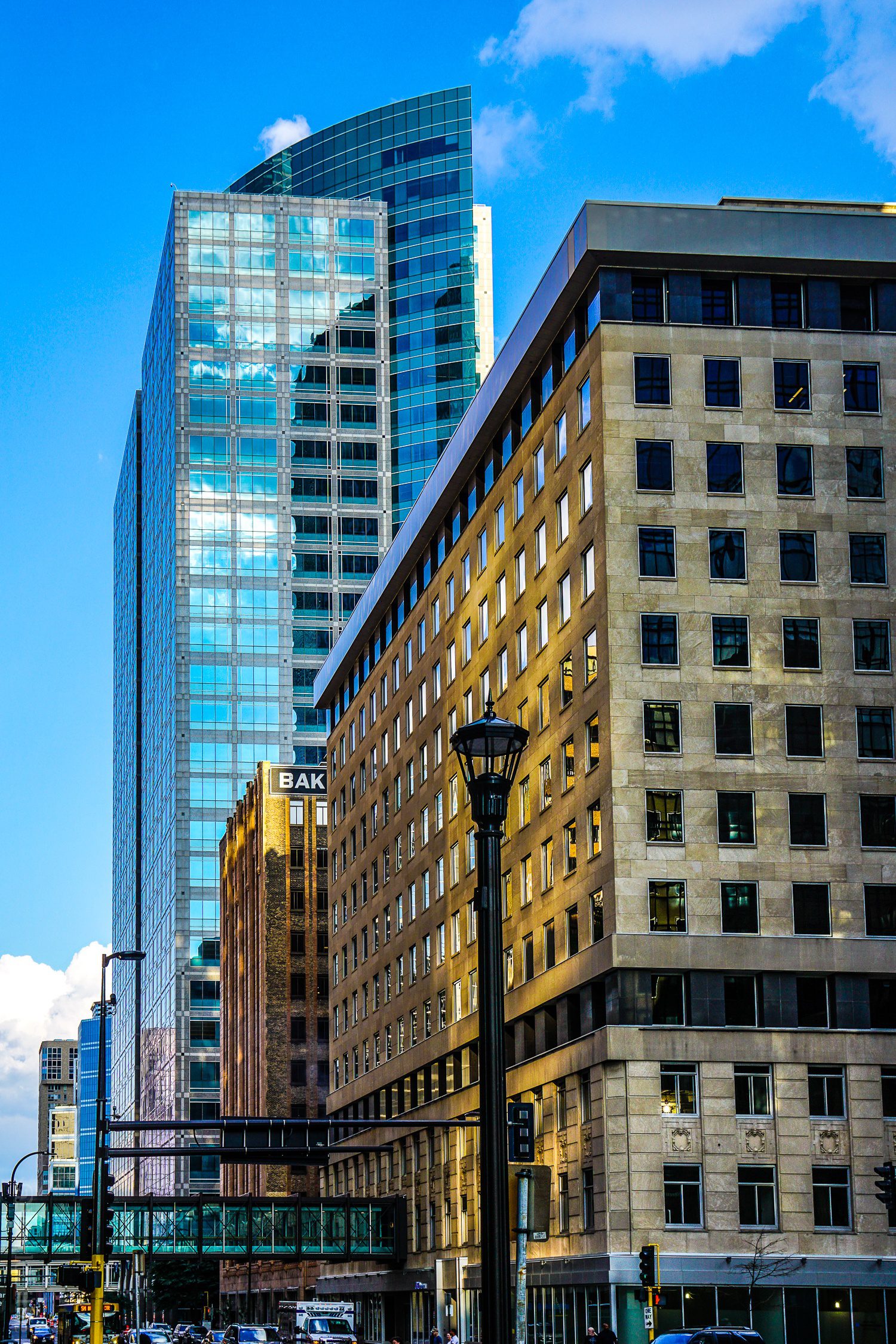 Buildings shimmering with reflected light from nearby glass walls.