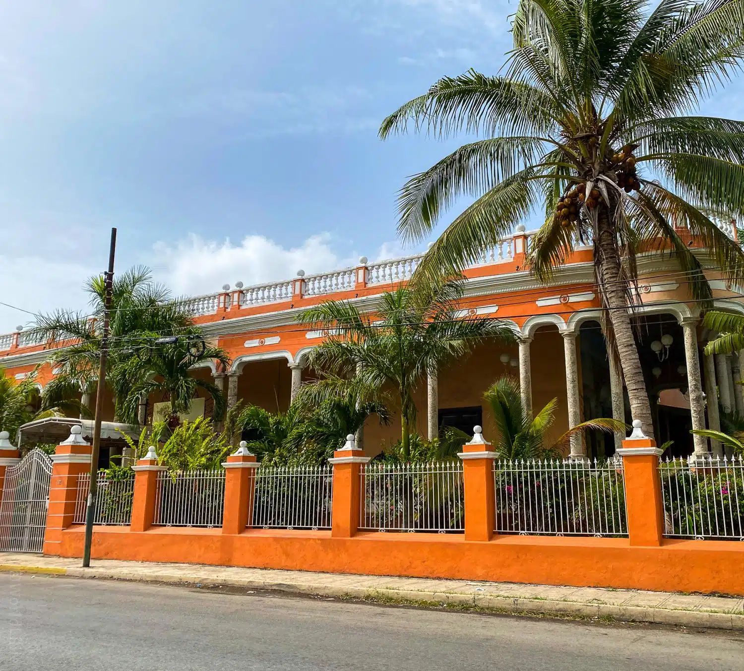 A bright orange building with palm trees.