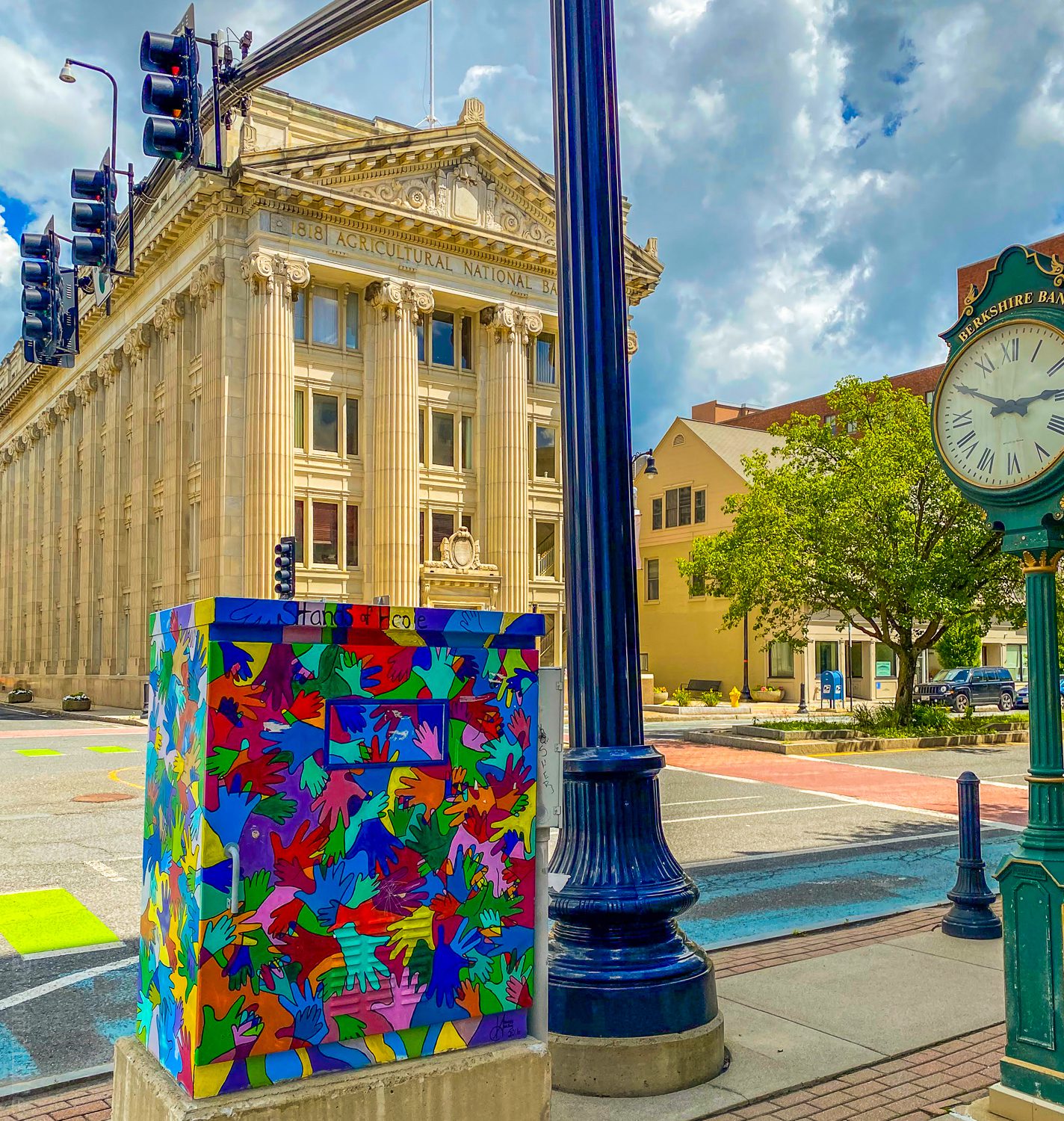 Public art and an old fashioned clock in front of First Agricultural Bank.
